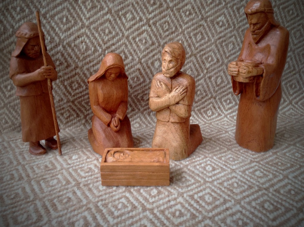 Hand-carved Nativity from Spanish Cedar, backdrop of handwoven goose-eye throw.