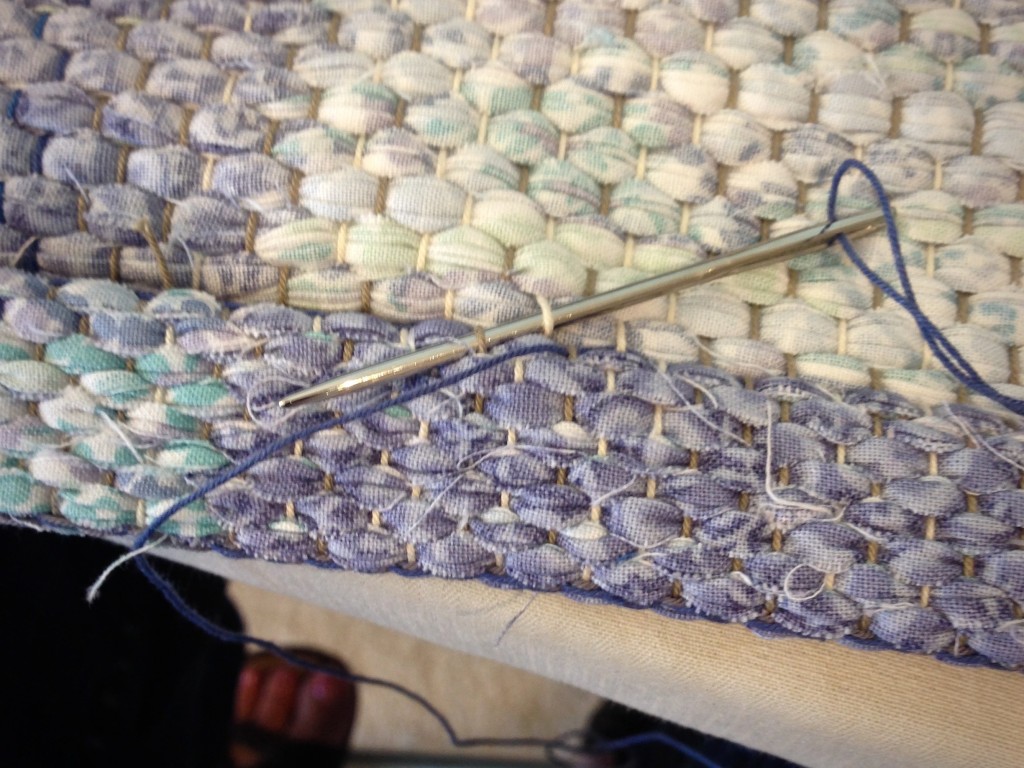 Hand-hemming rag rug.