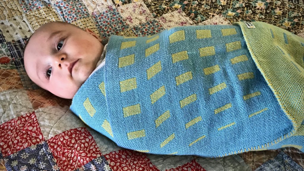 Handwoven baby blanket. (Resting on his great-great-grandmother's quilt.)